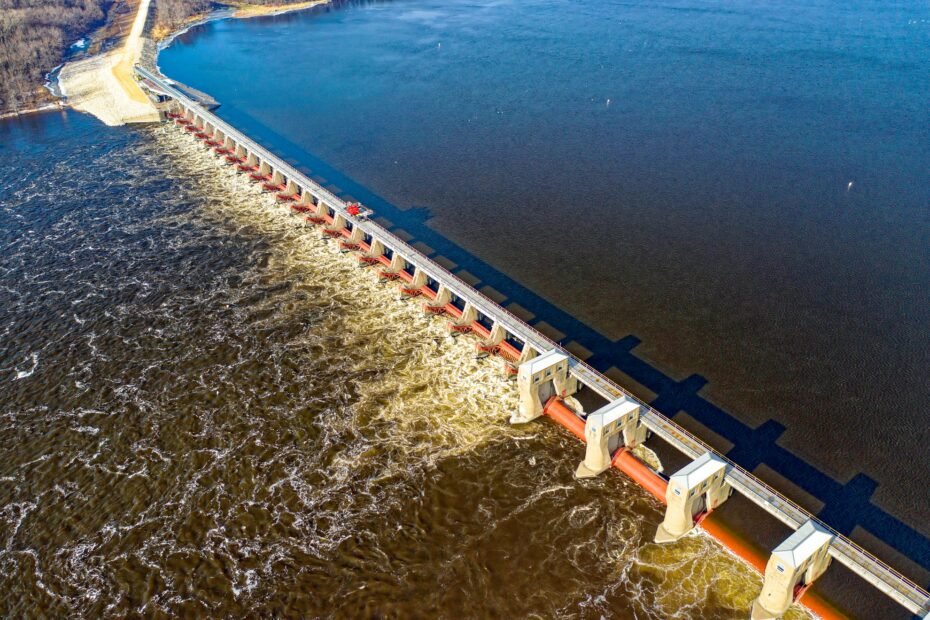 Drone shot capturing the Alma Dam's architectural structure on the Mississippi River in daylight.